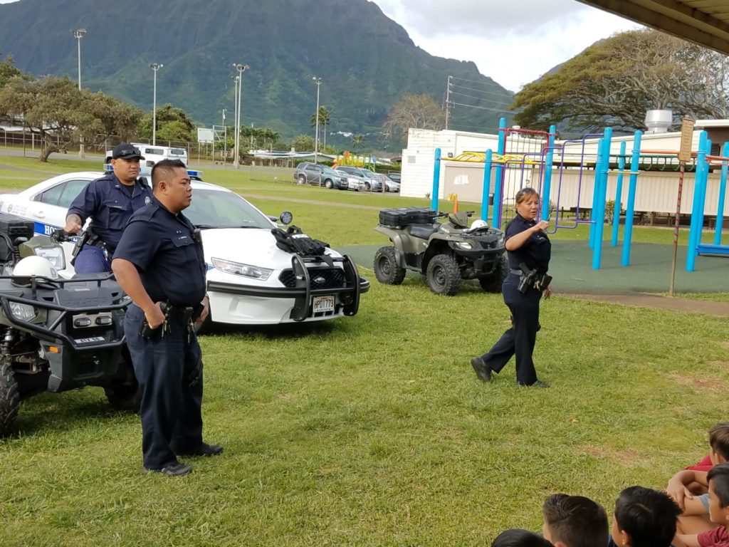 Three officers speaking to school kids