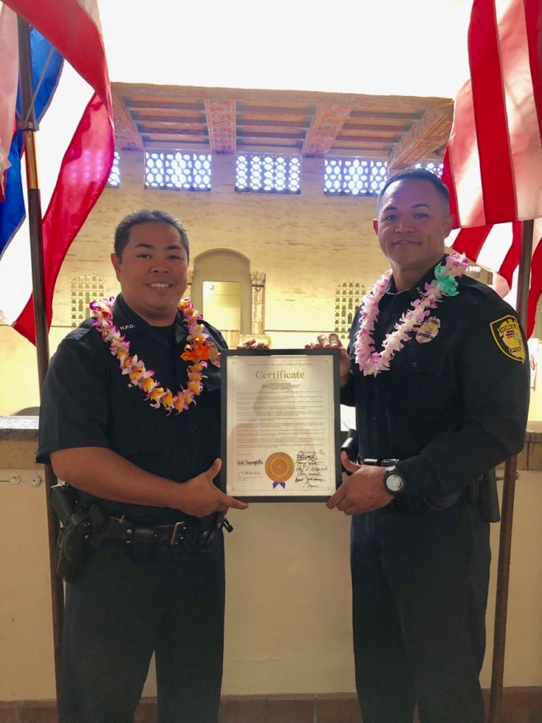 Two District 4 officers receiving an award at Honolulu Hale