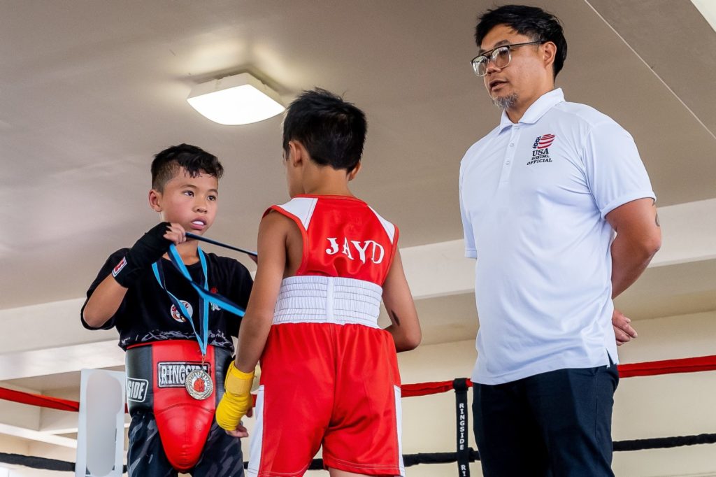 PAL Boxing. Child awarding a competitor with a medal