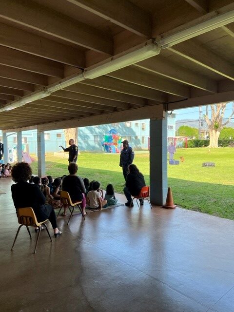 Officers speaking to children at Alphabetland Waipahu