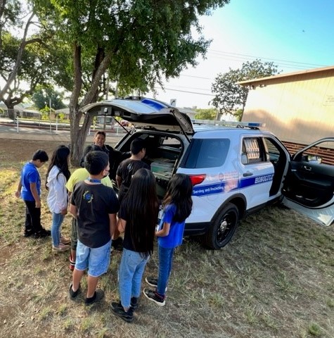 Officer and students at a Career Day event at August Ahrens Elementary School