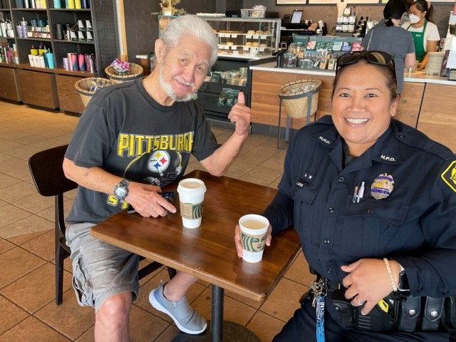Officer and community member at a Coffee with a Cop event