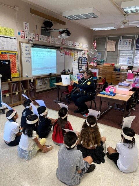 Officer reading to students at Kalei’opu’u Elementary School
