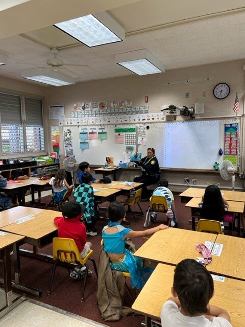 Officer reading to students at Kalei’opu’u Elementary School