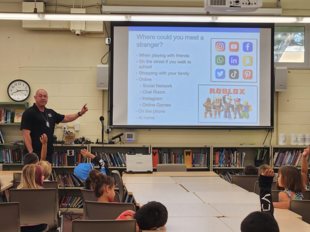 Officers presenting to students at Haleiwa Elementary School about stranger danger.