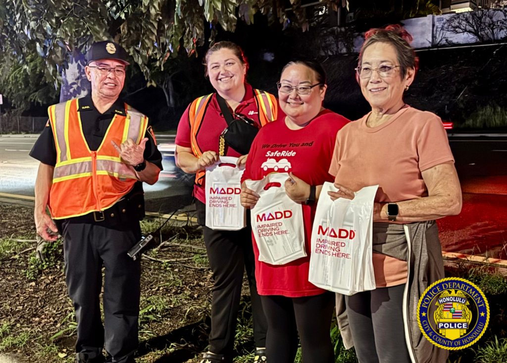 Traffic Division Honors Azalia Park with Sign-Waving and Checkpoint. Over the weekend, officers from the Traffic Division partnered with SafeRide Hawaiʻi, MADD Hawaiʻi, and the Keiki Injury Prevention Coalition Hawaiʻi for a sign-waving event in remembrance of Azalia Park, a victim of impaired driving in December 2020. Officers then conducted a sobriety checkpoint in the area, where sober drivers were thanked with a gift from MADD Hawaiʻi for choosing to drive sober. 🚗💙 Remember, making good decisions affects us all and helps ensure safer roads for everyone. 🌟 #SaferRoadsTogether #DriveWithAloha #SafeEveryMile