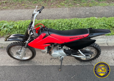 Photo of a red colored electric motorcycle/dirt-bike.