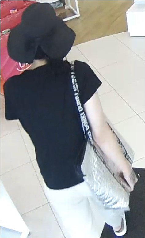 Unknown female suspect carrying an insulated thermal tote bag with Donki printed on the straps captured on surveillance camera