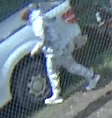 Unknown male suspect wearing a long-sleeved camo print sweat suit captured on surveillance camera