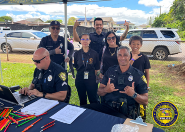 Group of HPD officers, Mililani High School student intern, and community members posing for a photo.