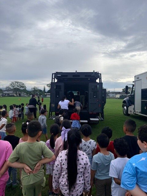 Officers with HPD & HPD Specialized Services Division explain their role in the department to students at Kaala Elementary