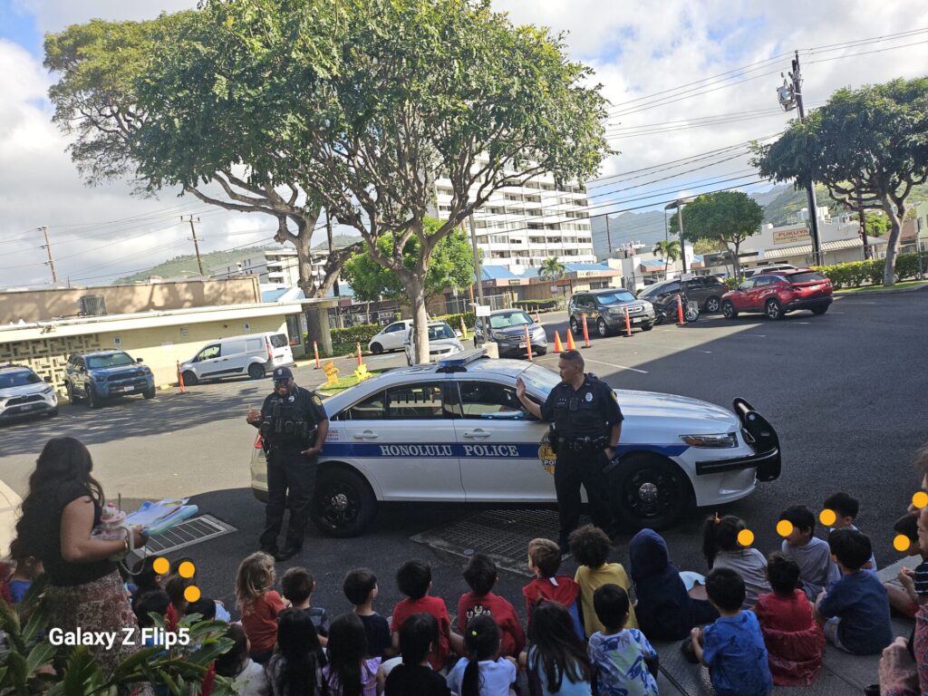 HPD Officer providing an up-close view of a patrol vehicle to students.