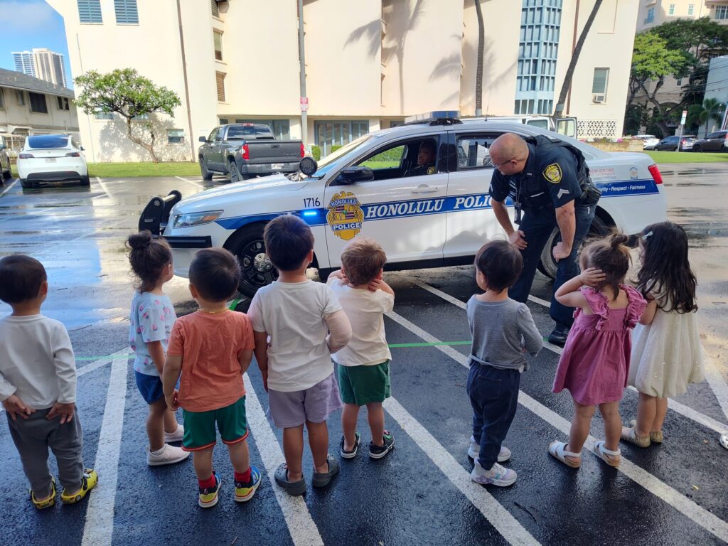 HPD Officer providing an up-close view of a patrol vehicle to students.