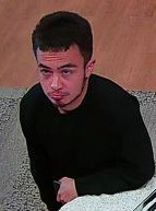 Unknown male with a chin strap fade beard and full tattoo on left lower leg shown on surveillance camera