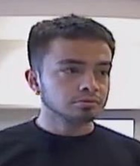 Unknown male with a chin strap fade beard and full tattoo on left lower leg shown on surveillance camera