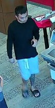 Unknown male with a chin strap fade beard and full tattoo on left lower leg shown on surveillance camera