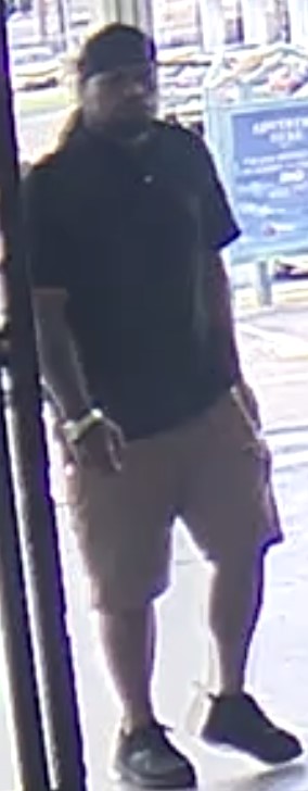 Unknown male suspect with a large build and prominent wristwatch on right arm shown on surveillance camera