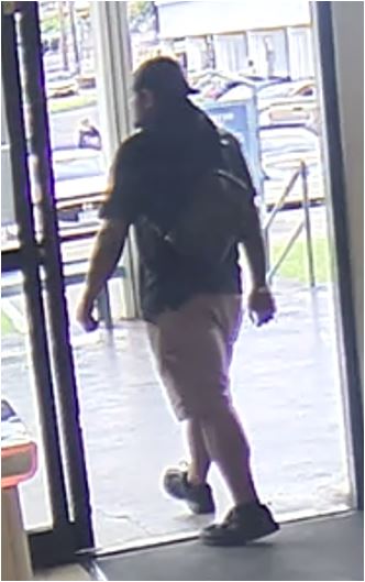 Unknown male suspect with a large build and prominent wristwatch on right arm shown on surveillance camera