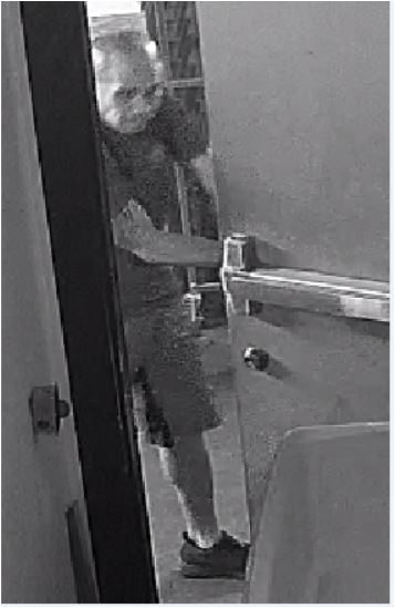 Unknown bald male suspect with tattoos on bicep and leg shown on surveillance camera
