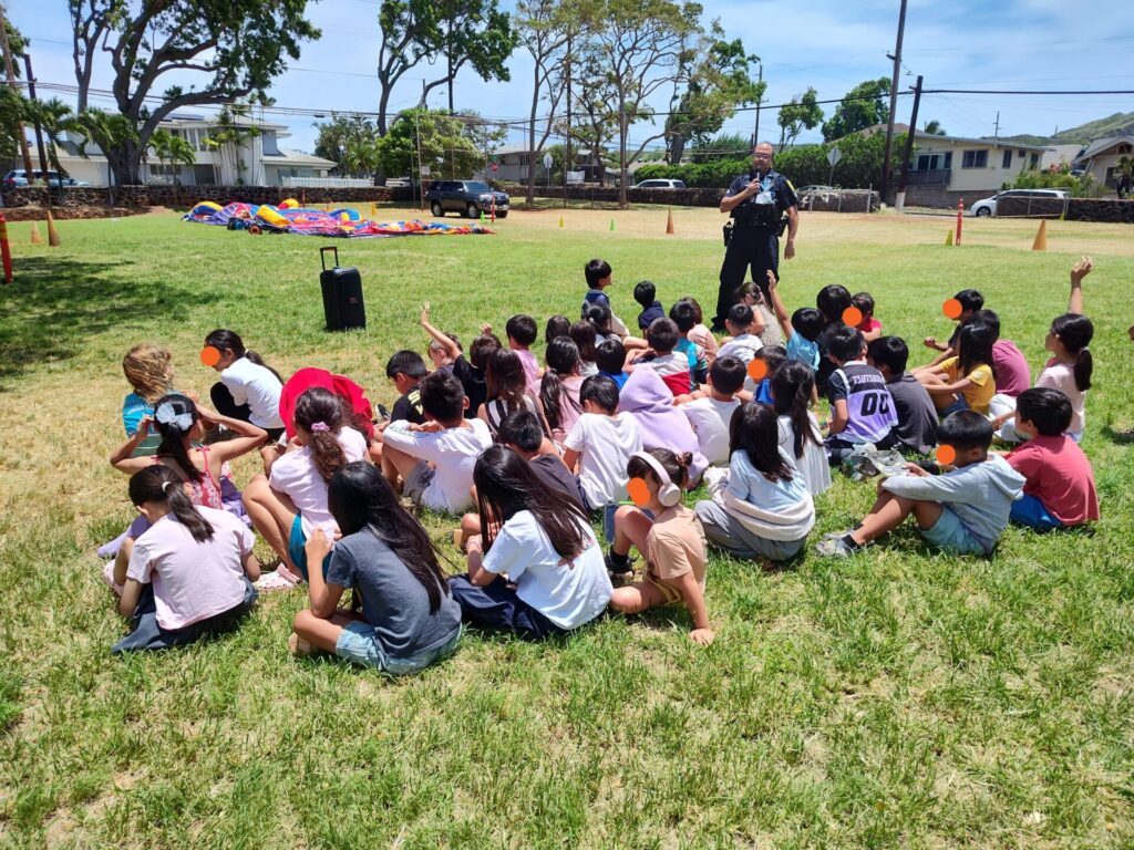 HPD Officer providing an up-close view of uniform and equipment to students.