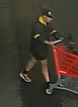 Unknown male with mismatched covered shoes pushing a shopping cart