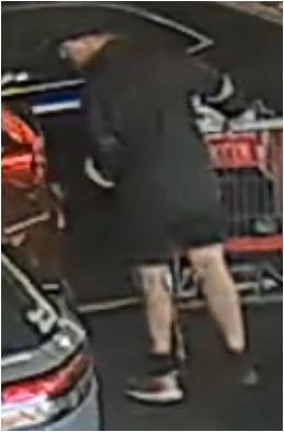 Unknown male with mismatched covered shoes pushing a shopping cart