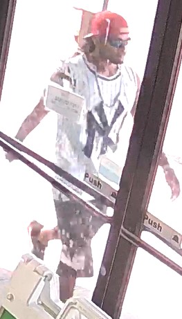 Unknown male wearing a backwards baseball cap and NY Yankees tank top as shown on surveillance camera