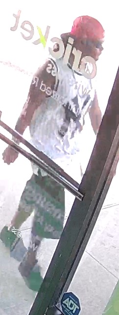 Unknown male wearing a backwards baseball cap and NY Yankees tank top as shown on surveillance camera
