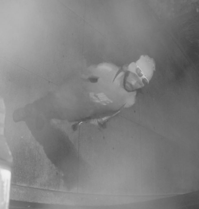 Unknown Micronesian male suspect wearing a beanie and carrying a skateboard as shown on surveillance camera