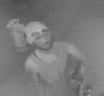 Unknown Micronesian male suspect wearing a beanie and carrying a skateboard as shown on surveillance camera