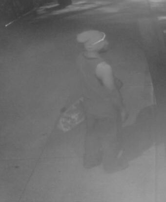 Unknown Micronesian male suspect wearing a beanie and carrying a skateboard as shown on surveillance camera
