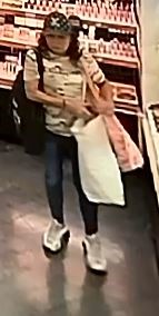 Unknown female suspect with a black and white Louis Vuitton hat and white athletic shoes as shown on surveillance camera