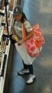 Unknown female suspect with a black and white Louis Vuitton hat and white athletic shoes as shown on surveillance camera