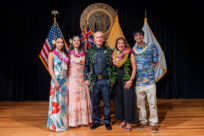 A wide shot of Chief David Lazar standing with his family on stage at the Mission Memorial Auditorium on the day of his swearing in.