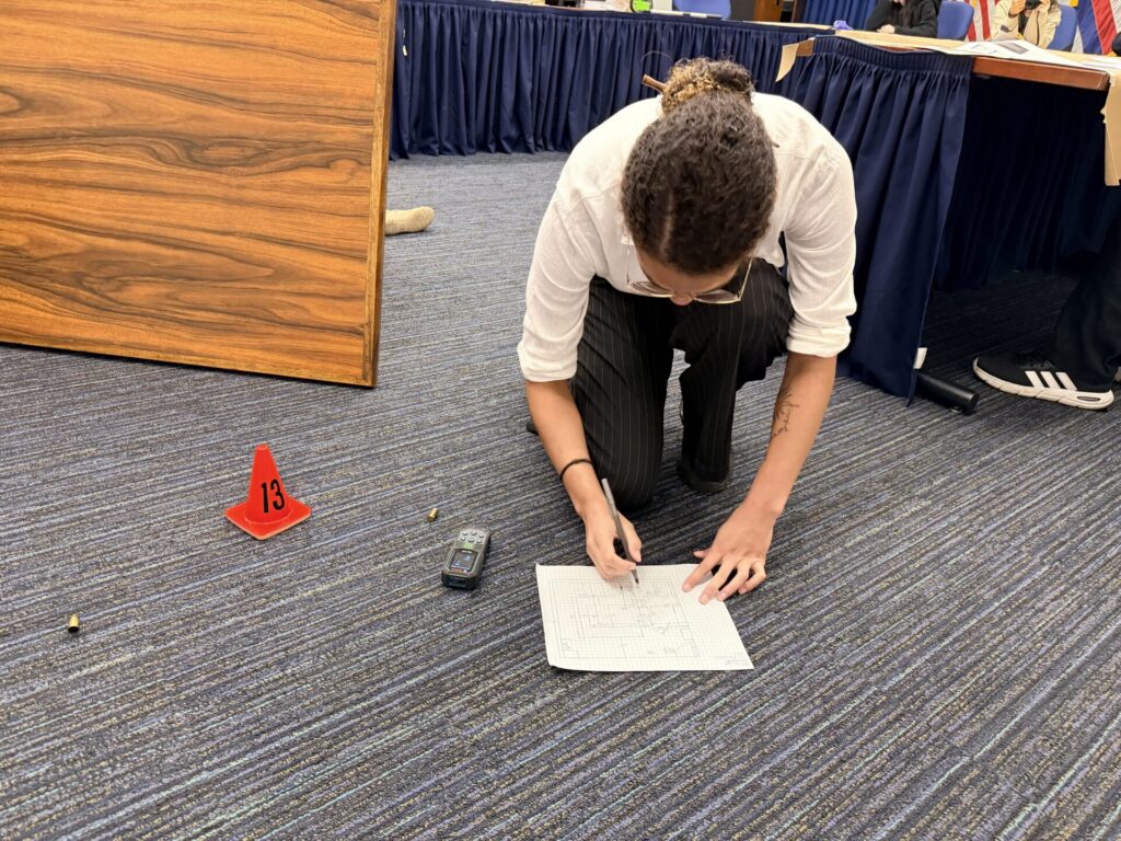 SIS Intern Kylie Rhodes maps out a mock crime scene