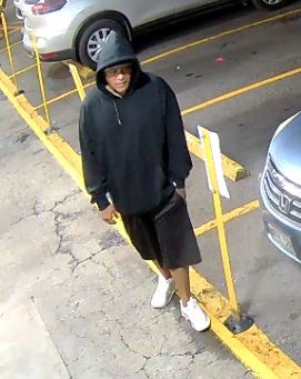 Unknown male suspect wearing a hooded sweatshirt over a baseball cap as shown on surveillance camera