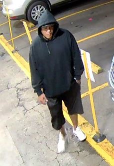 Unknown male suspect wearing a hooded sweatshirt over a baseball cap as shown on surveillance camera
