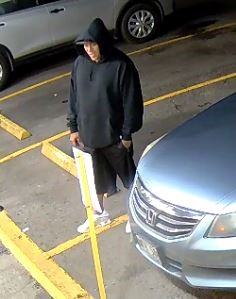 Unknown male suspect wearing a hooded sweatshirt over a baseball cap as shown on surveillance camera