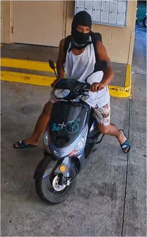 Unknown male suspect on a black moped with stickers on the front above and below the headlight as shown on surveillance camera