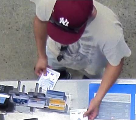 Unknown male suspect wearing a red NY Yankees cap and lanyard around his neck as shown on surveillance camera