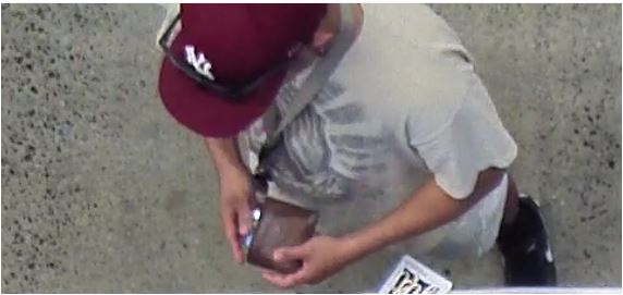 Unknown male suspect wearing a red NY Yankees cap and lanyard around his neck as shown on surveillance camera