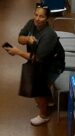 Unknown female suspect carrying a slingbag with sunglasses on her head and hair pulled back in a bun as shown on surveillance camera