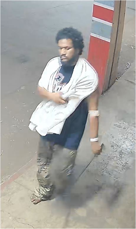 Unknown barefoot male suspect wearing a bath towel around his neck and medical wristband as shown on surveillance camera
