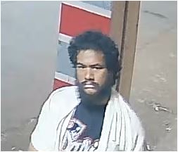 Unknown barefoot male suspect wearing a bath towel around his neck and medical wristband as shown on surveillance camera